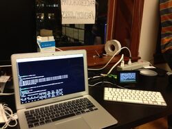 A laptop running a terminal and a keyboard next to it