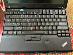 Original condition of laptop: worn keyboard and cracked palm rest